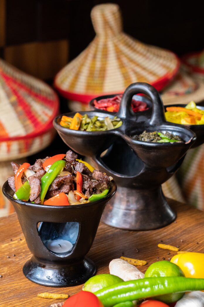 Vertical shot of delicious Ethiopian food with fresh vegetables on a wooden table Traditional African Food
